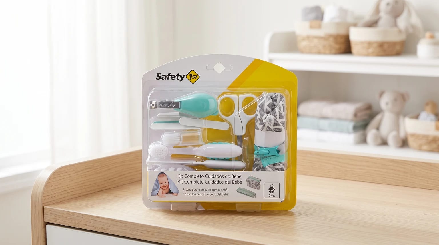 Kit de cuidados para bebê da Safety 1st na embalagem, sobre uma cômoda de madeira em um quarto infantil.