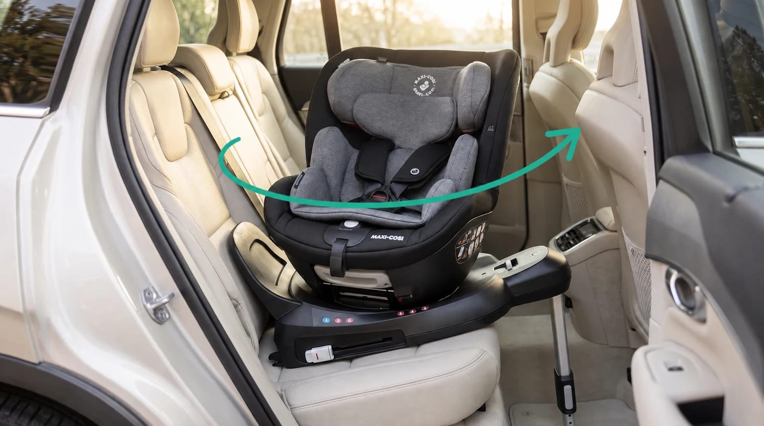 Cadeirinha Maxi-Cosi Spinel 360° preta e cinza instalada com perna de apoio, com uma seta turquesa indicando o giro.