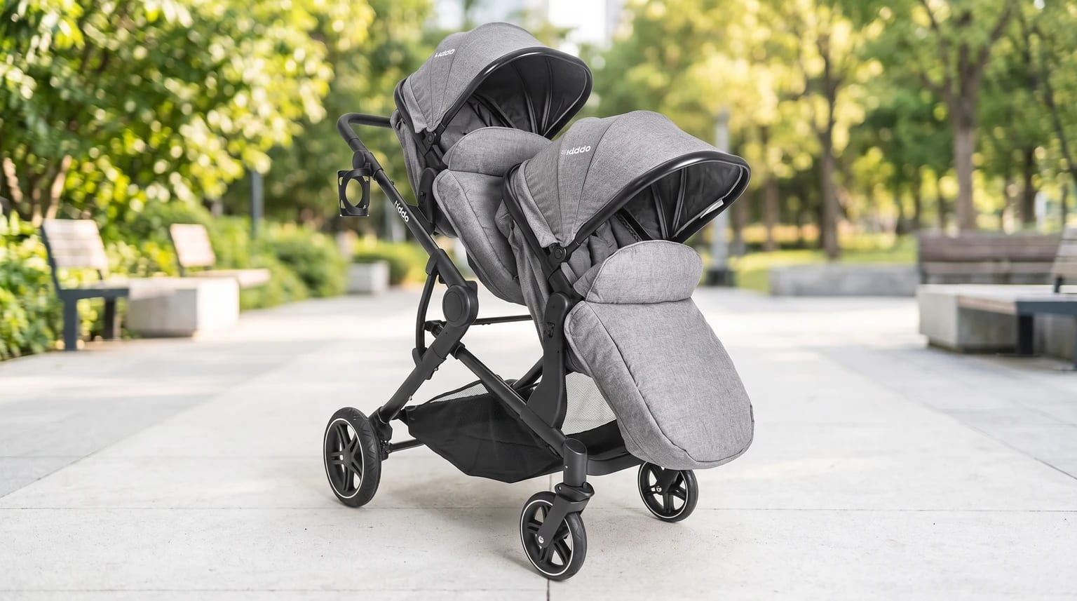 Carrinho Kiddo Pair cinza, vazio e com um módulo atrás do outro em um parque.