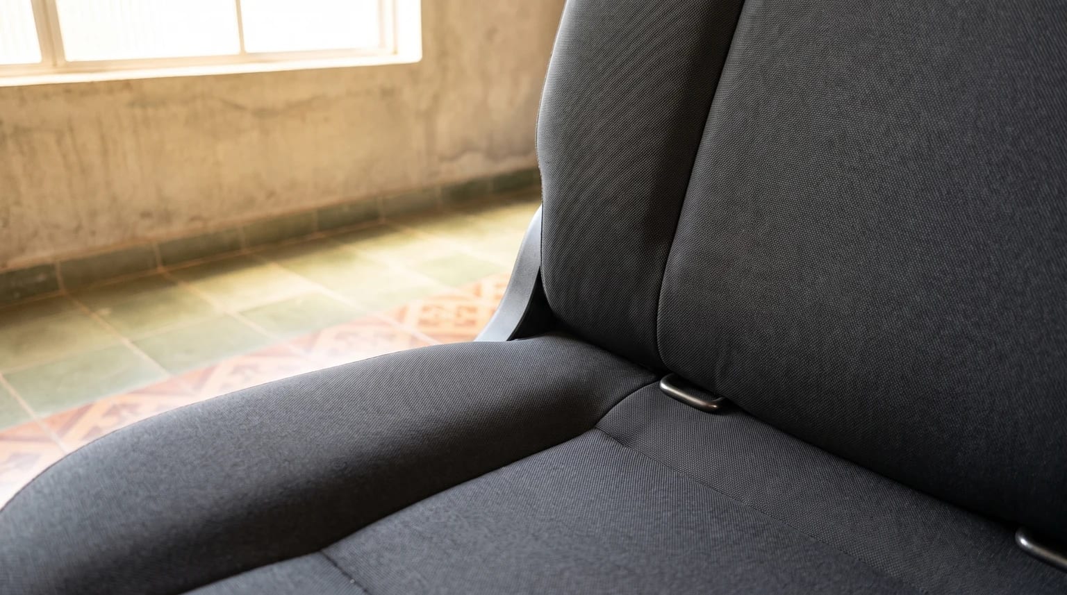 Duas ancoragens inferiores ISOFIX na junção entre o assento e o encosto do banco traseiro.