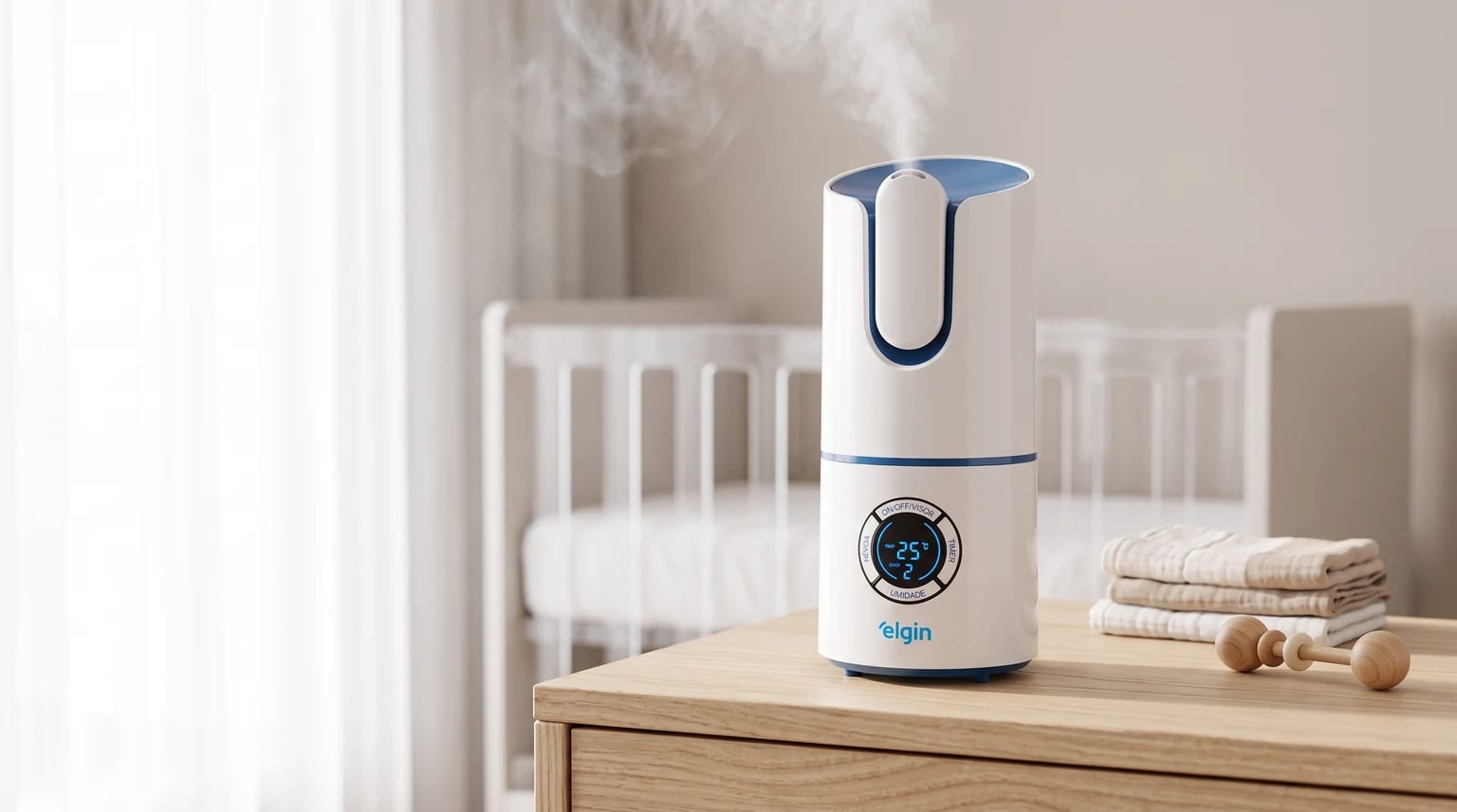 Umidificador de ar Elgin branco e azul em funcionamento sobre uma cômoda de madeira no quarto do bebê, com um berço ao fundo.