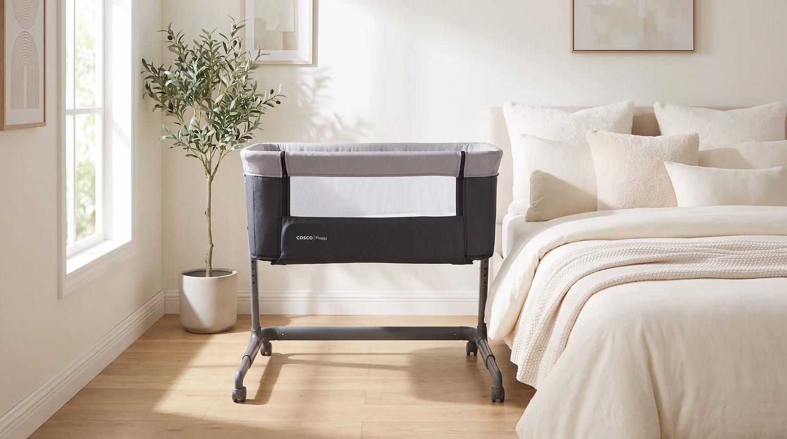 Berço Cosco Pluggy cinza com lateral de tela, posicionado ao lado de uma cama de casal.