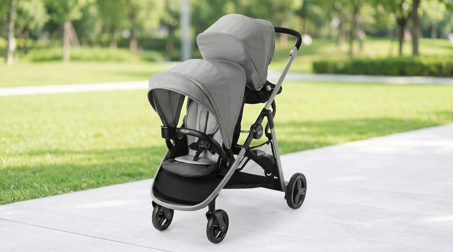 Carrinho Graco Ready2Grow LX 2.0 cinza, vazio e com um assento atrás do outro em um parque.