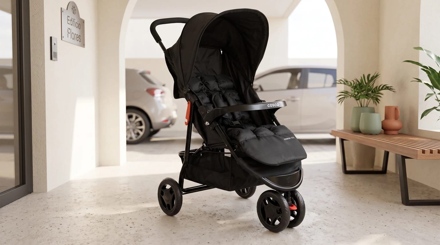 Carrinho de bebê Cosco Toffy preto na entrada iluminada de um condomínio, com plantas e um carro ao fundo.