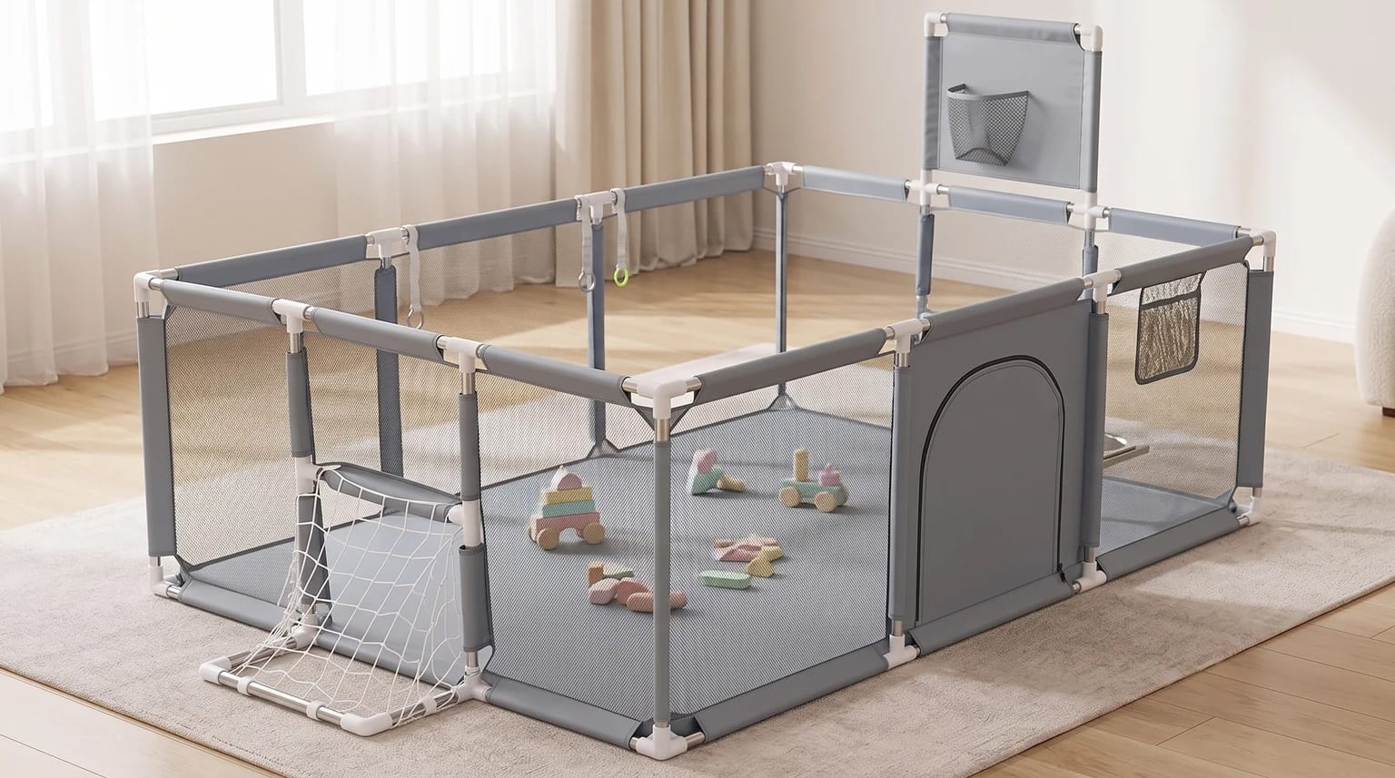 Cercadinho grande cinza, com mini-gol e painel elevado com bolso, montado sobre um tapete com brinquedos de madeira dentro.